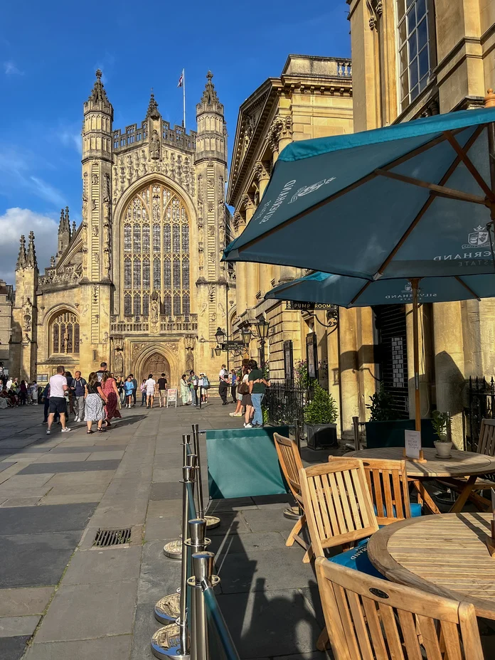 Terraced seating outside of The Pump Room overlooking Bath Abbey in the sunshine